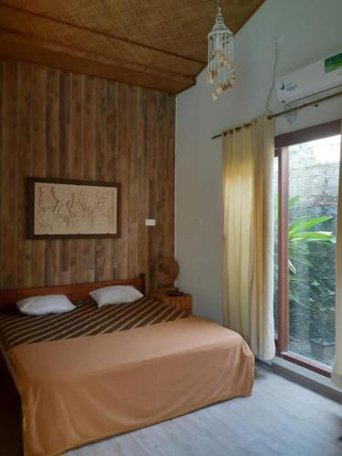 a bedroom with a bed and a large window at Calmness Villa Syariah in Sekupang