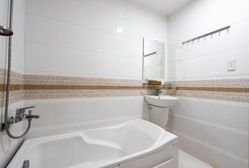 a white bathroom with a sink and a toilet at King Hotel Saigon Airport in Ho Chi Minh City