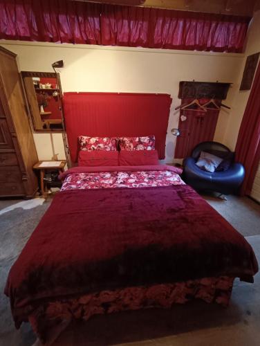 a bedroom with a red bed and a chair at Bed and Breakfast Opus 209 in Zwolle