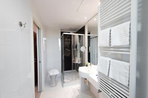 a white bathroom with a sink and a mirror at Neo Hotel in Bresso