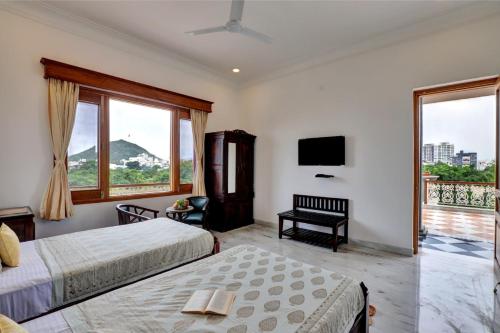 a hotel room with two beds and a television at Shree Deogarh Niwas in Udaipur
