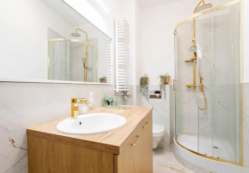 a bathroom with a sink and a shower and a toilet at Vanilla Apartment Ochota in Warsaw