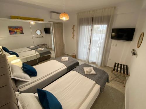 a bedroom with three beds and a mirror at Momo's House in Nikiti