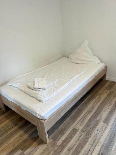 a bed with white sheets on a wooden floor at Timeless: 3 Zimmer Maisonette-Wohnung in Villingen-Schwenningen in Villingen-Schwenningen