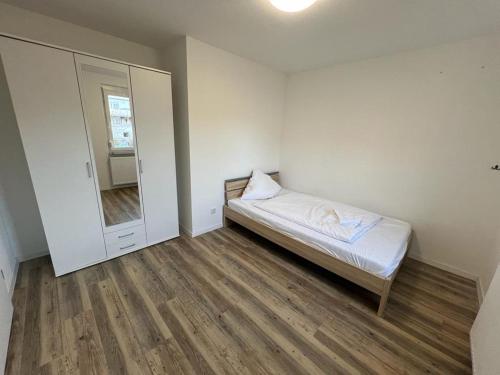a small bedroom with a bed and a mirror at Timeless: 3 Zimmer Maisonette-Wohnung in Villingen-Schwenningen in Villingen-Schwenningen