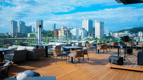 een terras met tafels en stoelen en een skyline van de stad bij SIHA Hotel & Casino in Sihanoukville