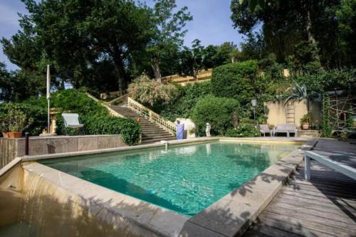 une femme debout en face d'une piscine dans l'établissement Cleo - Maison avec vue exceptionnelle, à Villeneuve-lès-Avignon
