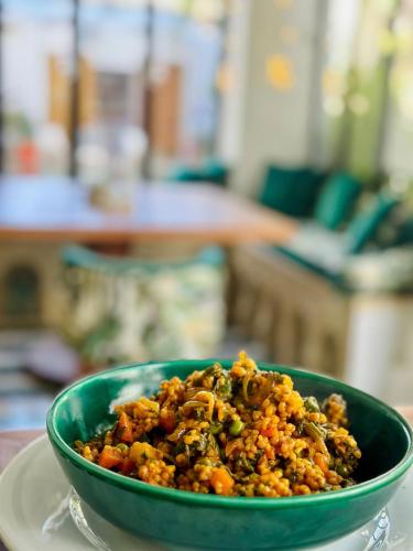 a green bowl of food on a white plate at Dar El Gaied in Nabeul