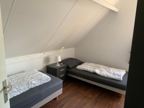 a bedroom with two beds and a night stand at Kustverhuur, Park Scheldeveste Zwin 065 in Breskens