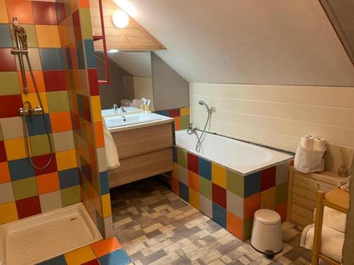 a colorful bathroom with a tub and a sink at Chez nous piste noire in Briançon