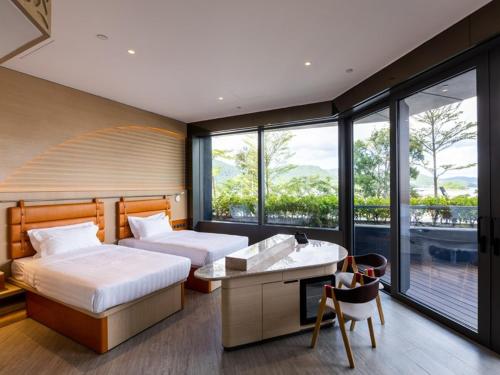 um quarto com 2 camas, uma secretária e janelas em WM Hotel Hong Kong, Vignette Collection em Hong Kong