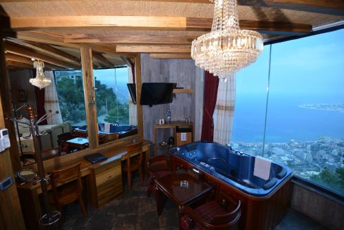 a bathroom with a tub and a television and a chandelier at Bay Lodge Boutique Hotel in Jounieh