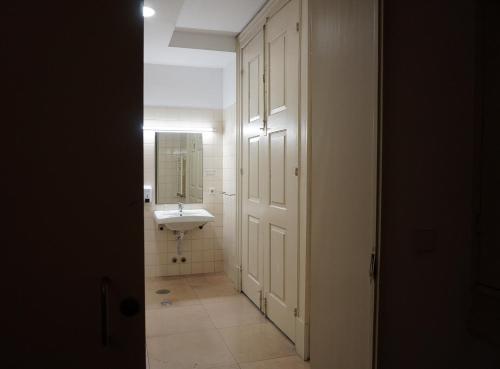 a white bathroom with a sink and a mirror at HI Guimaraes - Pousada de Juventude in Guimarães