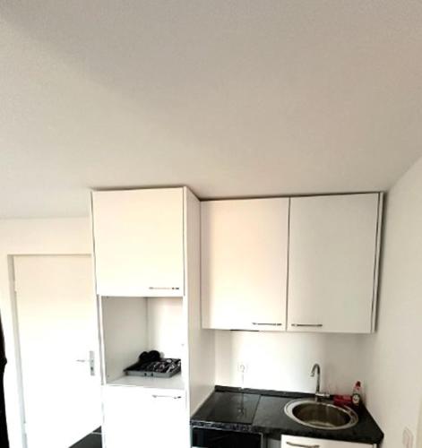 uma cozinha com armários brancos e um lavatório em Altbauloft, frisch saniert, mitten in Hameln em Hameln