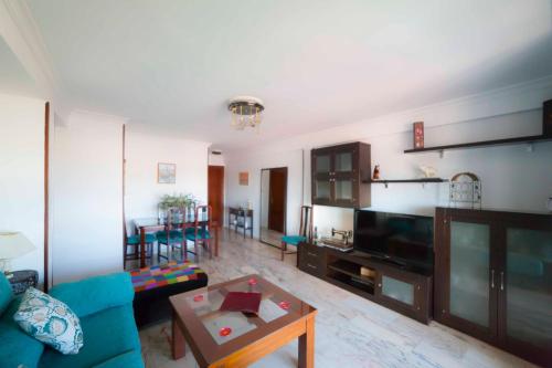 a living room with a blue couch and a table at SJE - Shiny apartment close to the river in Seville