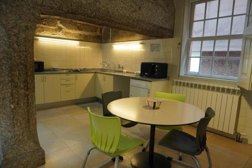 a kitchen with a table and chairs in a room at HI Guimaraes - Pousada de Juventude in Guimarães