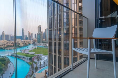 a chair on a balcony with a view of a city at Downtown Address Opera, Full Burj & Fountain view 5 Star 3 Bedroom by Gardenia Suites in Dubai
