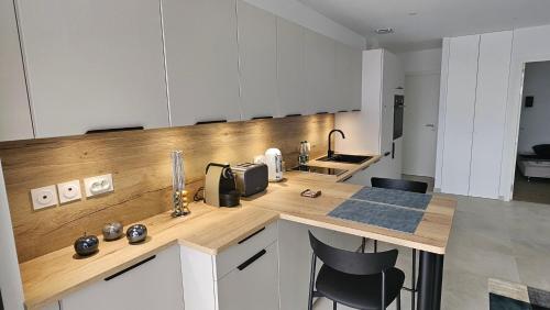 une cuisine avec des armoires blanches et un comptoir en bois dans l'établissement Le Cosy - joliment aménagé - vue magnifique, à Sévrier