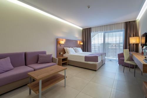 een hotelkamer met een bed en een bank bij Belvedere Hotel - All inclusive in Primorsko