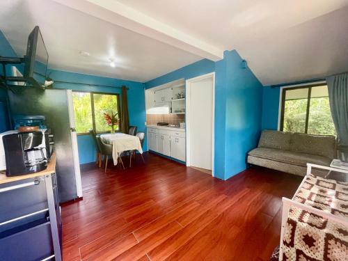 a living room with blue walls and wooden floors at Ngermid Oasis - 2 BD & 1 BA Cozy Cottage in Koror
