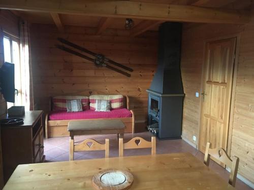 Cette cabane en rondins comprend un lit et un poêle à bois. dans l'établissement Chalet individuel, piscine sauna, à Saint-Étienne-en-Dévoluy