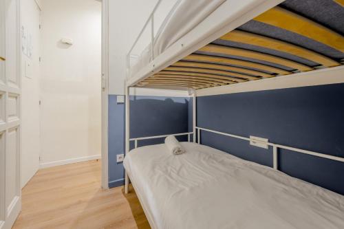 1 dormitorio con litera y pared azul en Central Apt 7px a 50 metros de Retiro-Museo del Prado en Madrid