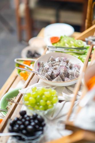 a table with plates of food and bowls of grapes at Bar Peepal Resort in Pokhara