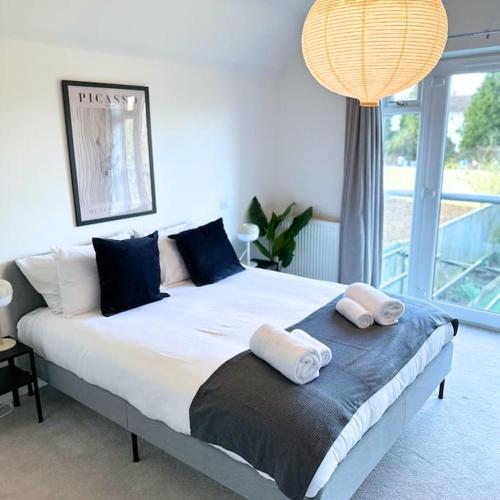 ein Schlafzimmer mit einem großen Bett mit zwei Kissen darauf in der Unterkunft Oxford Kidlington 6 Bed 5 mins to Oxford Parkway in Kidlington