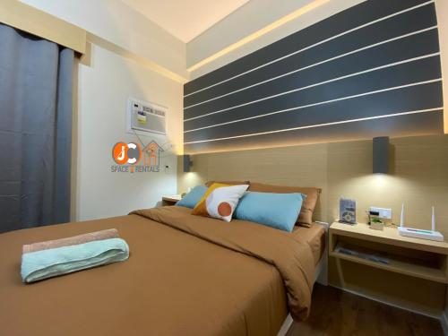 a bedroom with a large bed and a desk at JC SpaceRentals 127B Amani Grand Resort Residences, balcony pool view, Ground floor, 5 mins frm airport, free wifi, Netflix in Pusok