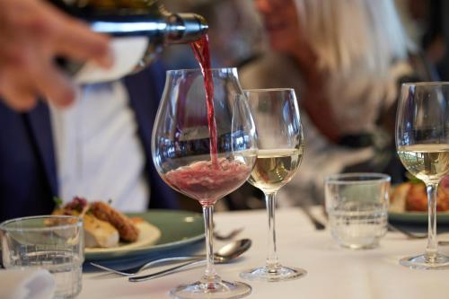 uma pessoa a derramar vinho branco em dois copos de vinho em Trinity Hotel og Konference em Fredericia