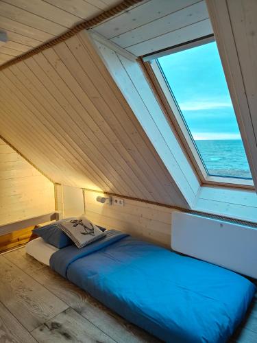 a bed in a room with a large window at Pakri Parun in Paldiski