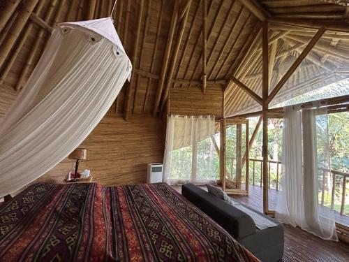a bedroom with a bed in a room with windows at Jero Tumbuk Private Villa in Selat