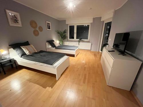 1 dormitorio con 2 camas y TV de pantalla plana en Monteurwohnung Neuss, en Neuss