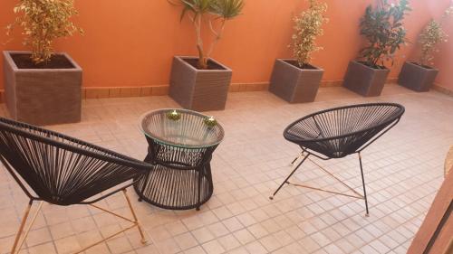 two chairs and a table in a room with potted plants at Holikeys - Marrakech - 2 Ch - Targa 006 in Marrakesh