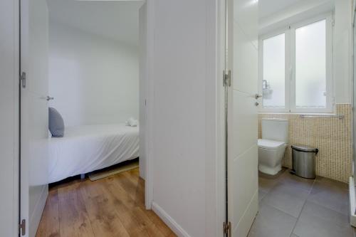 ein weißes Schlafzimmer mit einem Bett und einem WC in der Unterkunft Luxury Apartamento de 5hab en el centro de Madrid in Madrid