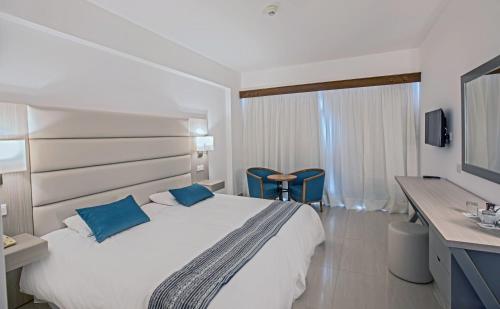 a hotel room with a large bed and a television at Anmaria Beach Hotel & Spa in Ayia Napa