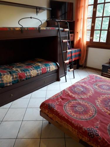 a bedroom with two bunk beds and a chair at Monolocale Abetone Cutigliano in Pian di Novello