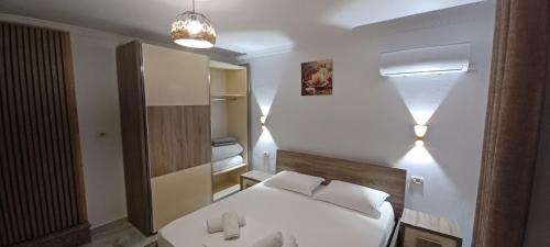 1 dormitorio con cama blanca y lavamanos en Hyka The Stone House, en Shkodër