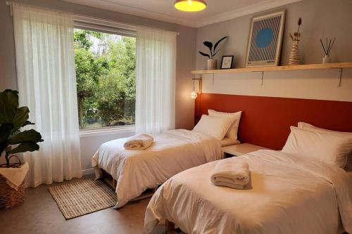 美德羅巴斯的住宿－The Yellow Koala - Vibrant Home in Medlow Bath，带窗户的客房内的两张床