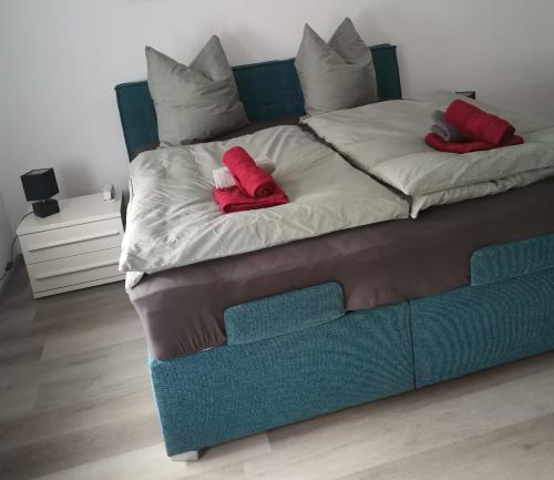 a large bed with two red pillows on it at Im Harzer Vogelnest Spatzennest in Bad Harzburg