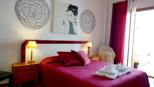 1 dormitorio con 1 cama roja y 2 toallas en Atico GOLFSTAR, en Villacosta