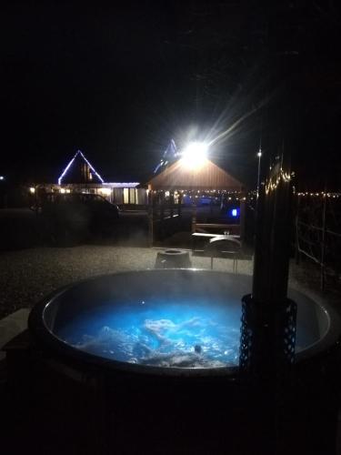 a hot tub at night with a building in the background at Casa Boila in Bîrsana