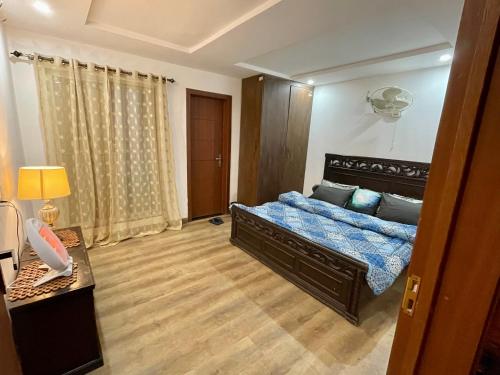 um quarto com uma cama com um edredão azul em Entire Studio Apartment em Islamabad