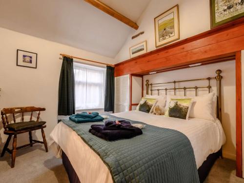 1 dormitorio con 1 cama grande y 1 silla en 1 Bed in Gamblesby 90416, en Kirkoswald