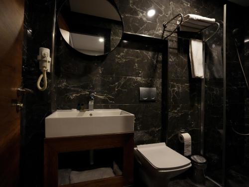a bathroom with a sink and a toilet and a mirror at Zalel Hotels Laleli in Istanbul