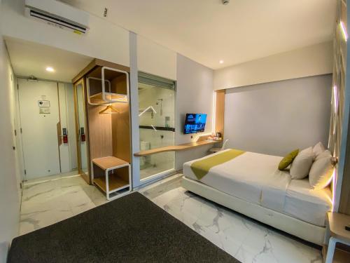 a bedroom with a bed and a walk in shower at Facade Hotel by Azana in Tawangmangu