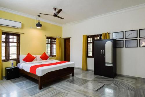 a bedroom with a bed with red pillows at Goroomgo Mks Inn Bhubaneswar in Bhubaneshwar