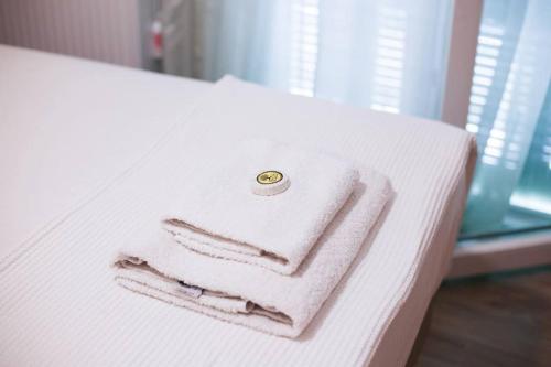 tre asciugamani impilati su un letto con un anello sopra di Spacious Apartment in Old Town - private parking a Salonicco