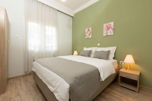 una camera da letto con un grande letto con pareti verdi di Spacious Apartment in Old Town - private parking a Salonicco