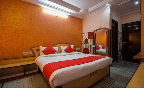 um quarto com uma cama grande e almofadas vermelhas em Pax in hotel em Udaipur